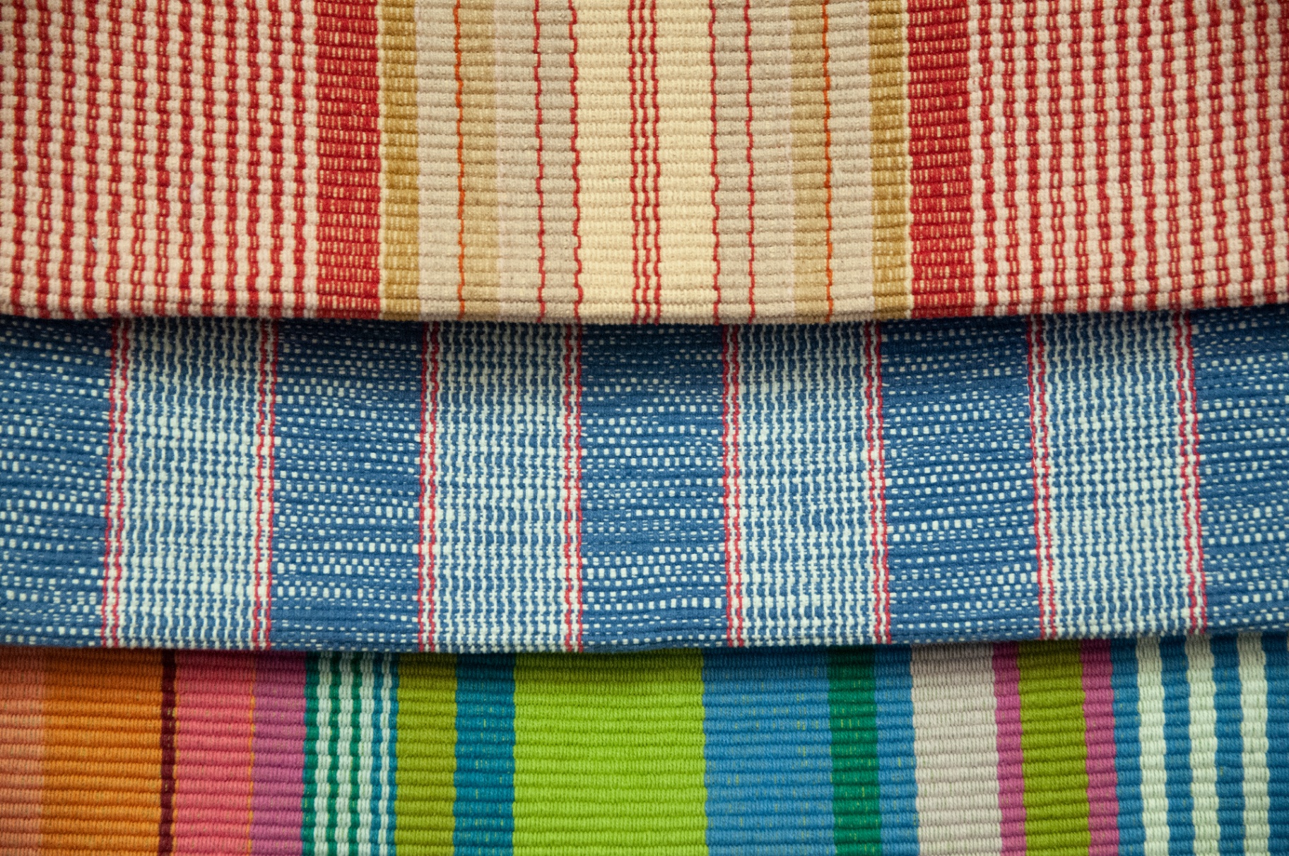 Dash & Albert striped cotton rugs, folded in a stack